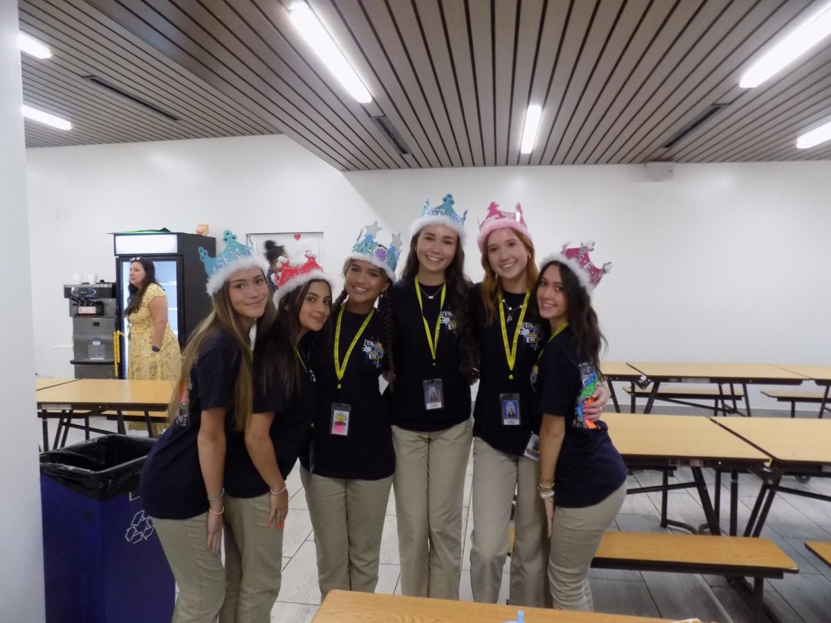 Juniors Sabine Harvey, Sienna Ingrasci, Kalli Robinson, Brooke Whiteman, Pheona McAndless, and Gianna Lopez celebrate step-up day in their crowns. 