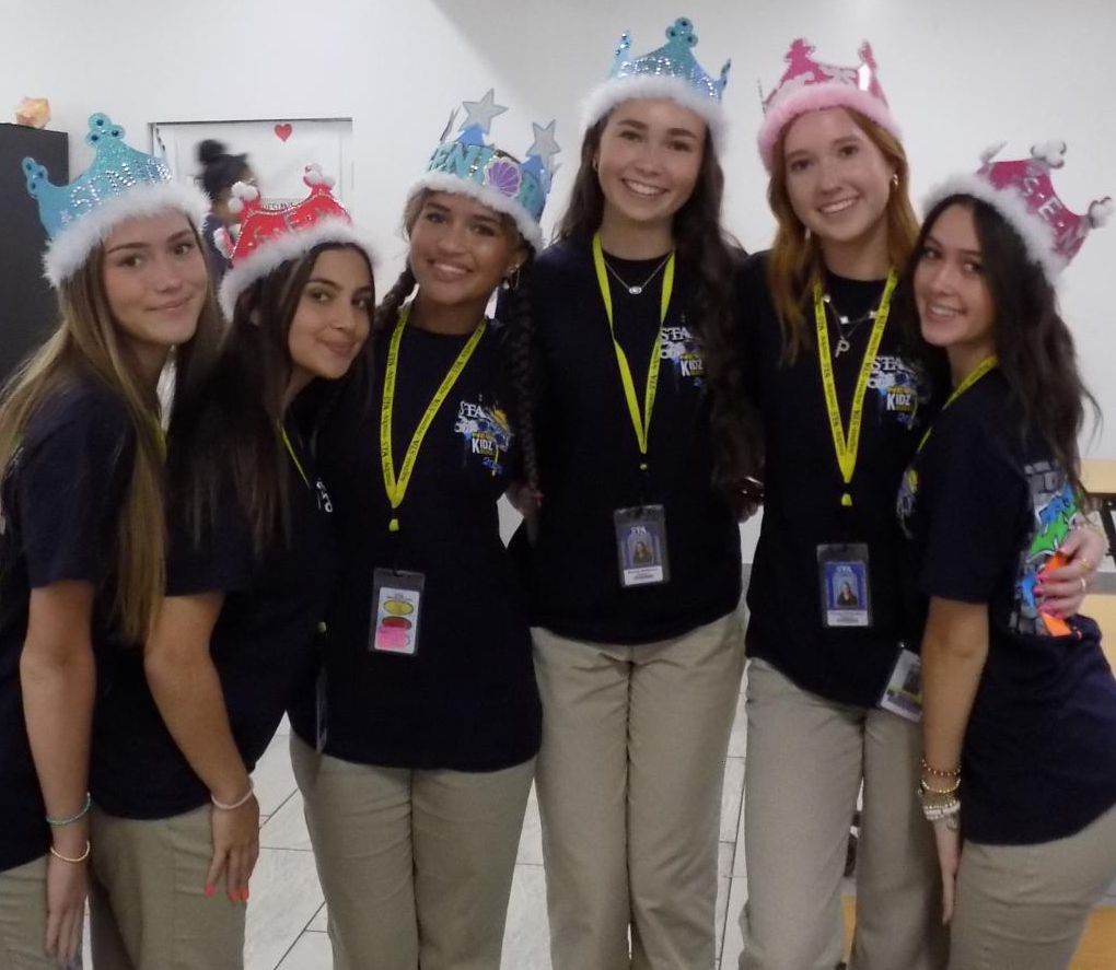 Juniors Sabine Harvey, Sienna Ingrasci, Kalli Robinson, Brooke Whiteman, Pheona McAndless, and Gianna Lopez celebrate step-up day in their crowns. 