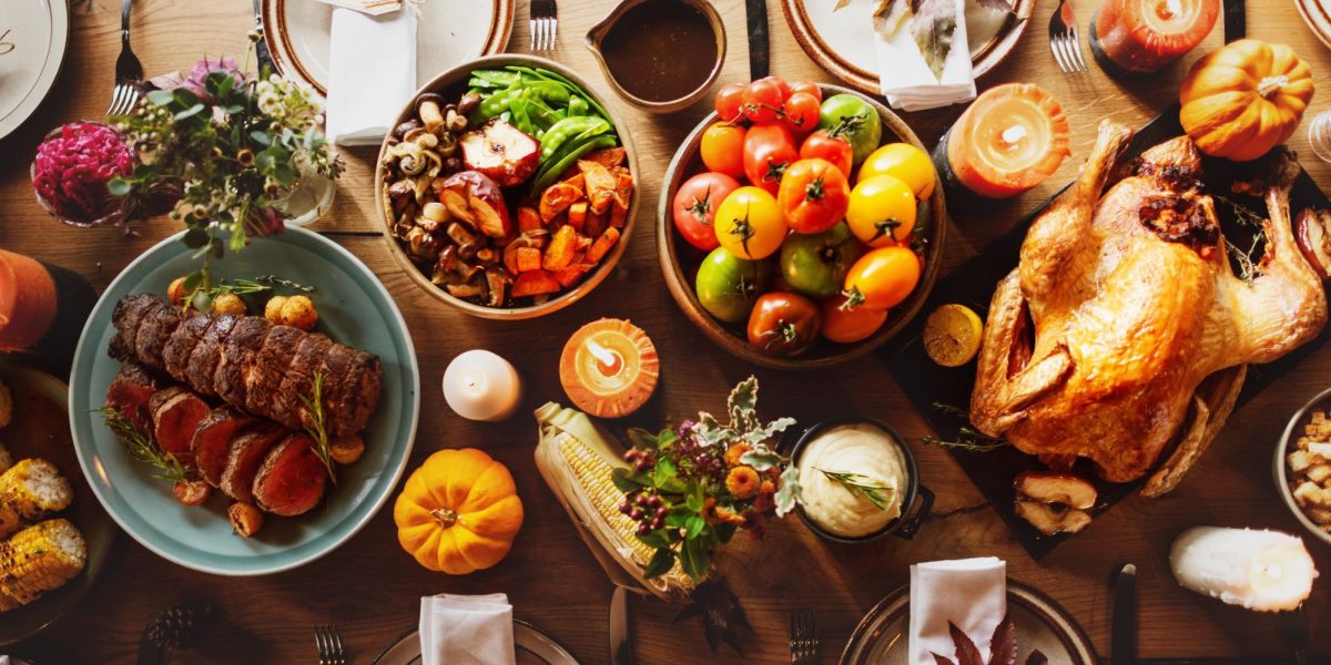 A festive Thanksgiving table with turkey, vegetables, and candles. Thanksgiving feast with turkey, colorful vegetables, and warm candles. Cozy Thanksgiving dinner setting. Thanksgiving turkey dinner. PHOTO BY RAWPIXEL.COM COURTESY OF SHUTTERSTOCK