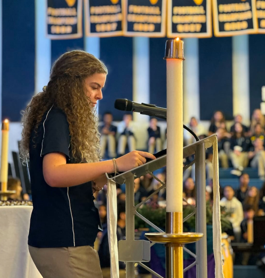 Elizabeth Gerhardt leads the students in song.

Photo by Aquinas Athletics