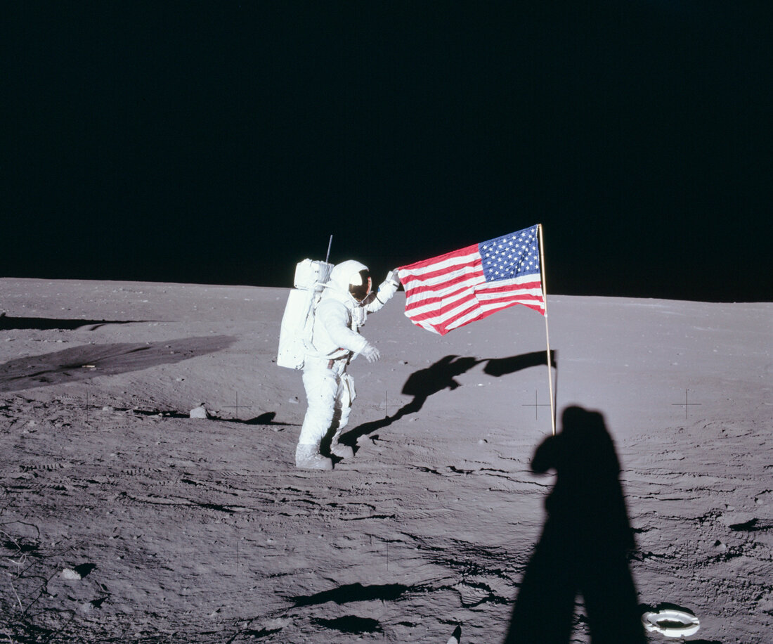 From NASA: Apollo 12 commander Charles "Pete" Conrad unfurls the United States flag on the lunar surface during the first extravehicular activity on Nov. 19, 1969.