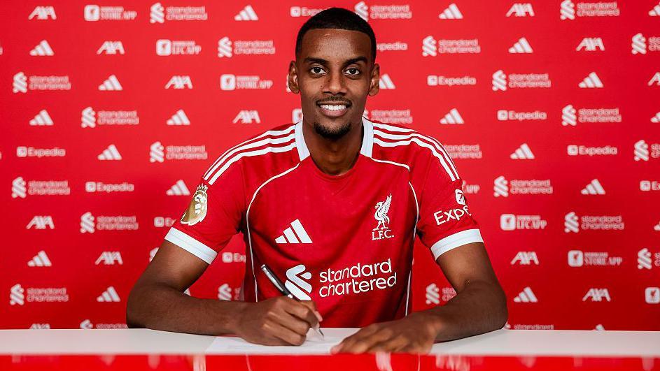 Alexander Isak signing for Liverpool.
(Liverpool FC via Getty Images)