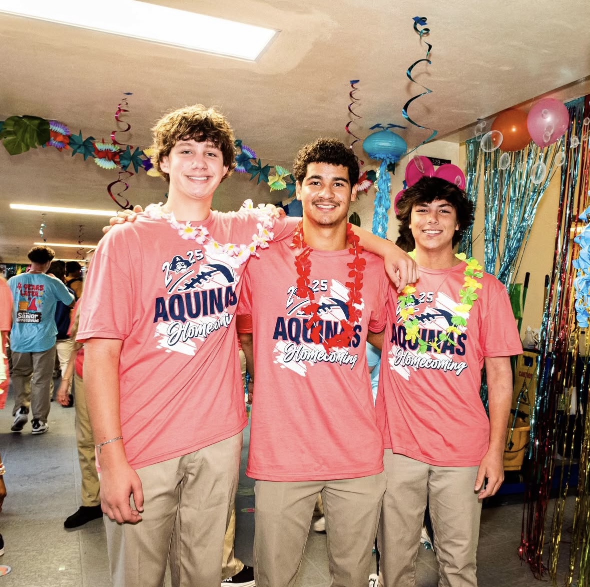 Juniors Blake Fernandez, Brooklyn Quinonez, and Derek Ruoff sporting their class shirts and Hawaiian leis.
