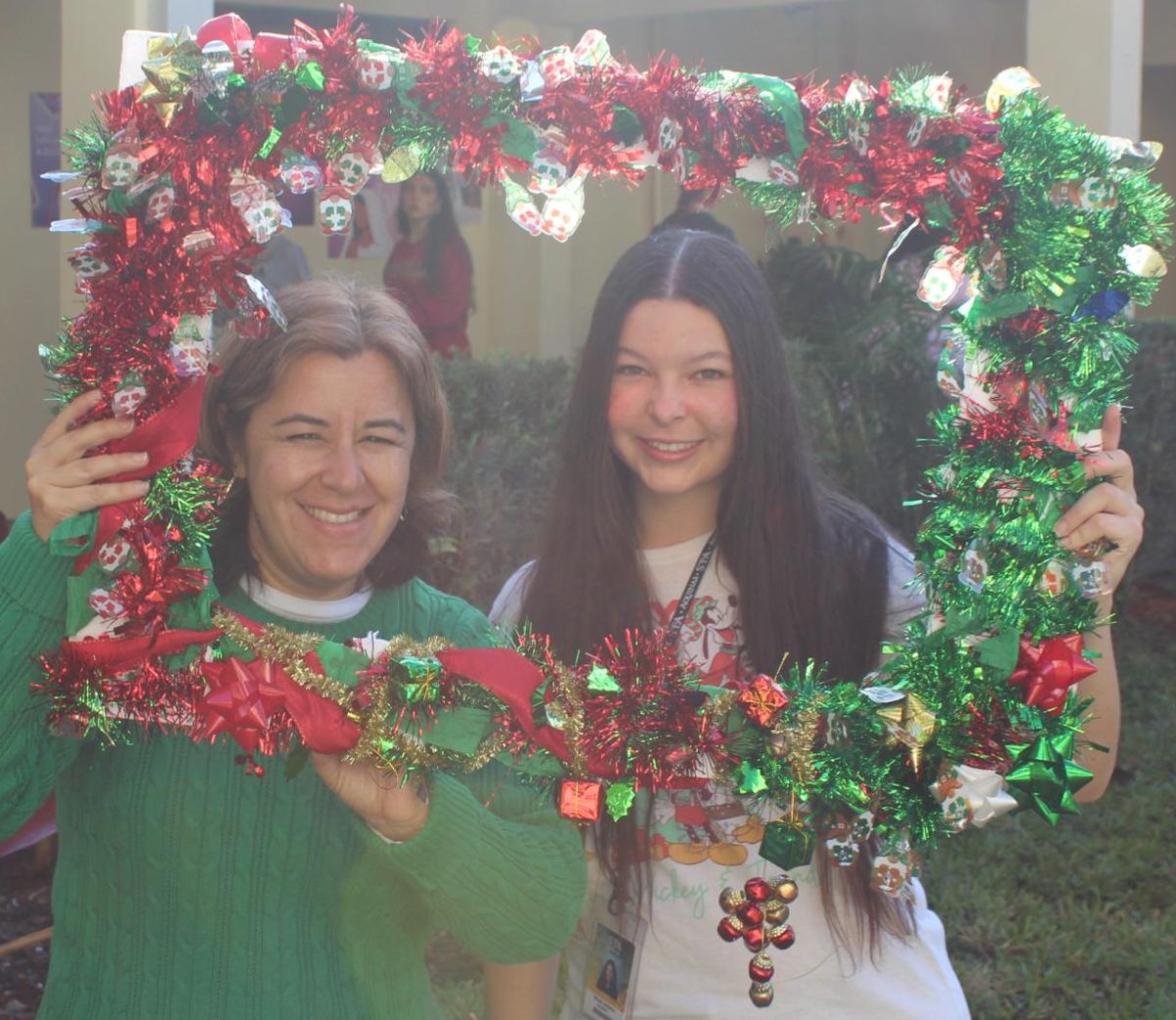 Theology teacher, Ana Diaz and sophomore, Rhea Adams pose for a holiday photo while embracing the holiday cheer.