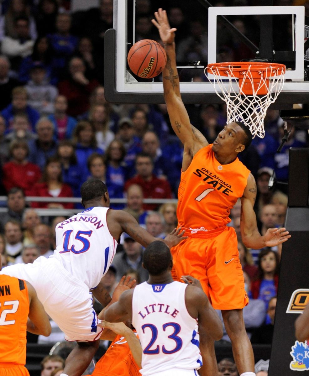 Oklahoma State Cowboys forward Jarred Shaw rejects a shot by Kansas Jayhawk guard Elijah Johnson (L) during the first half of the quarter-finals of the NCAA men's Big 12 basketball championship at the Sprint Center in Kansas City, Missouri, March 10, 2011. REUTER/Dave Kaup