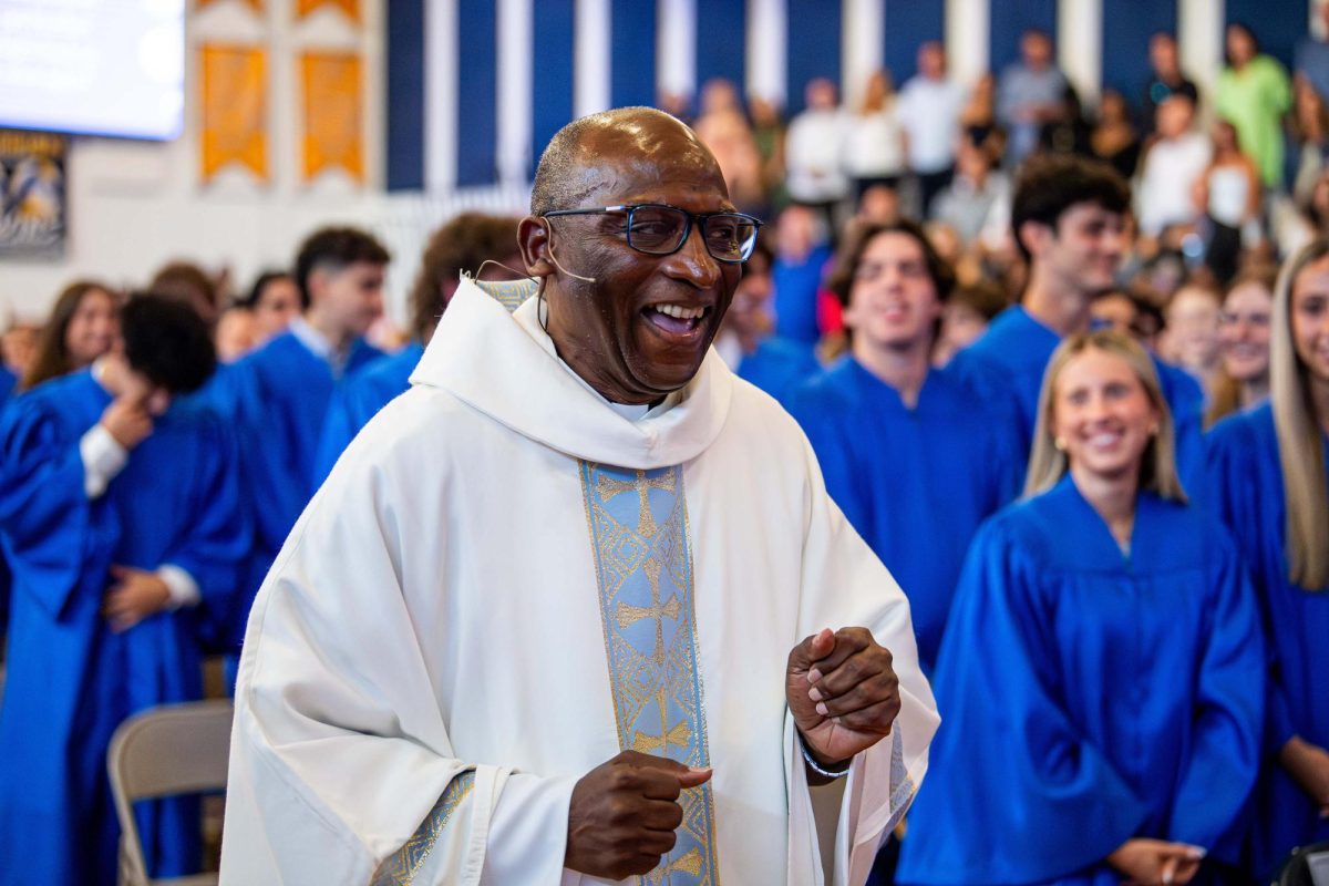 Father Celsus smiling with the graduating seniors.
-Courtesy of Aquinas Athletics.