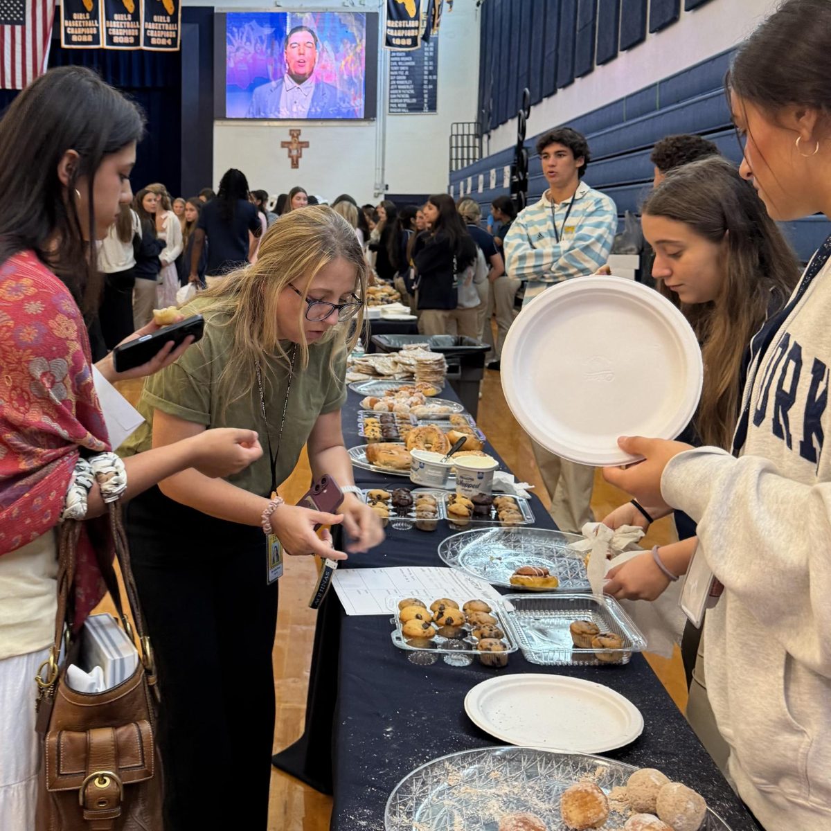 Alumni students and Ms. Piazza being served by another St. Thomas Aquinas Student and Kiley Opsal